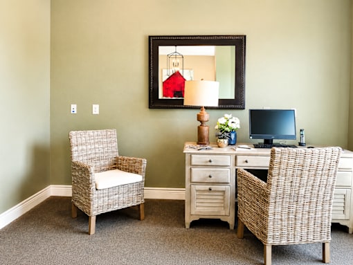 A room with a chair, desk, and a mirror.