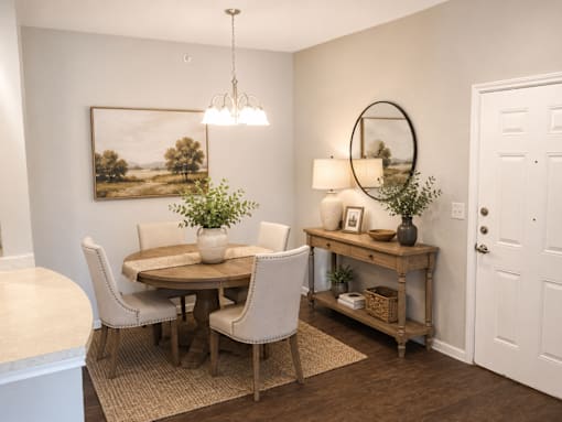 A dining room with a round table and chairs.