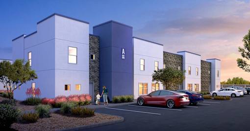 A modern building with a parking lot in front of it.
