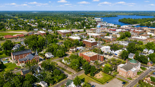 A small town with a waterfront and a church with a steeple.