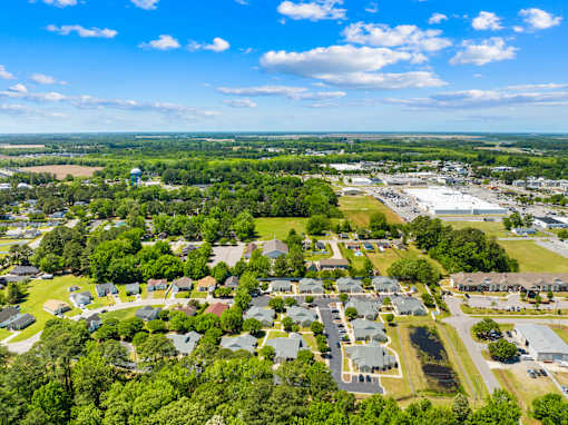 A bird's eye view of a residential area with houses and a parking lot.
