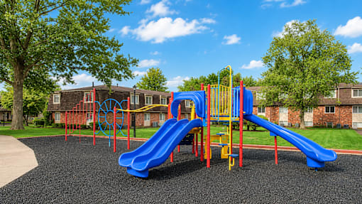 A playground with a blue slide and a yellow climbing frame.