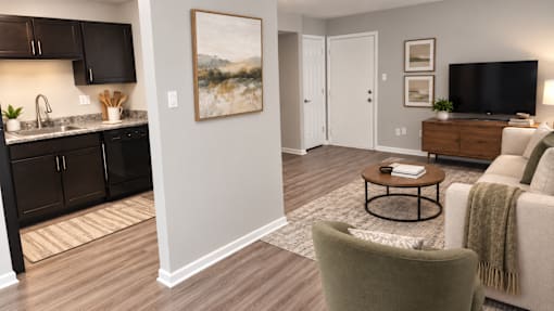 A living room with a grey couch and a painting on the wall.