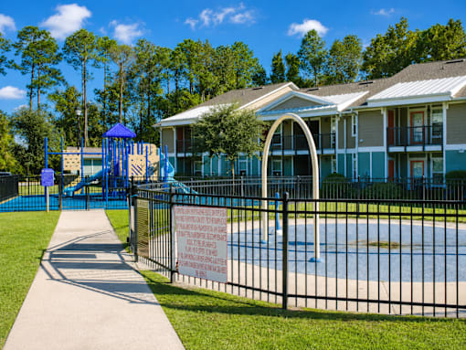 A playground with a blue slide and a sign on a fence.