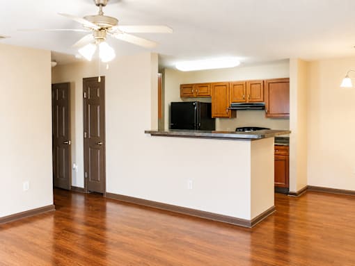 A kitchen with a black fridge and white counter.