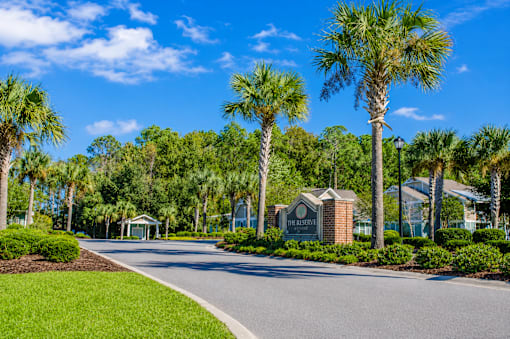 A street view of a residential area with a sign that reads "The Grove".