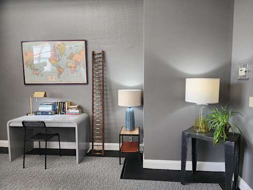 A room with a grey wall and a world map on the wall.