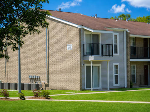 A brick building with a balcony and a sign on the wall.