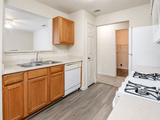 A kitchen with wooden cabinets and a white stove top oven.