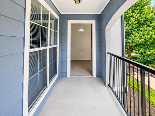 A blue house with a white door and a black railing.