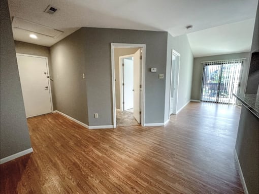 a living room with a hard wood floor and grey walls