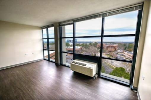 A room with a view of the city through large windows.