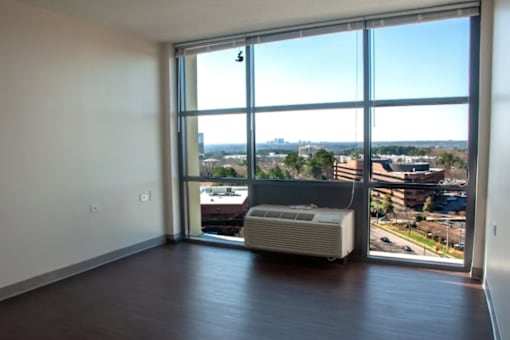 A room with a large window overlooking a cityscape.
