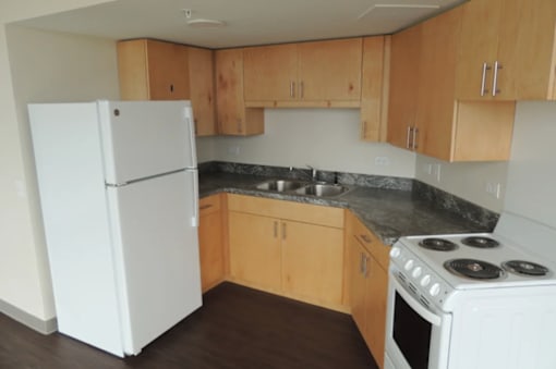 A kitchen with a white refrigerator and stove.