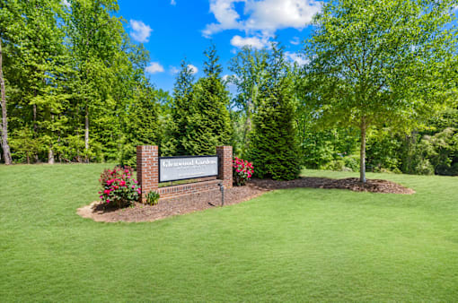 A sign in front of a green lawn that says "Oakcrest".