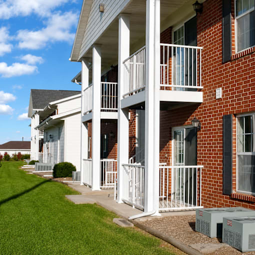 A row of houses with white balconies and black shutters.