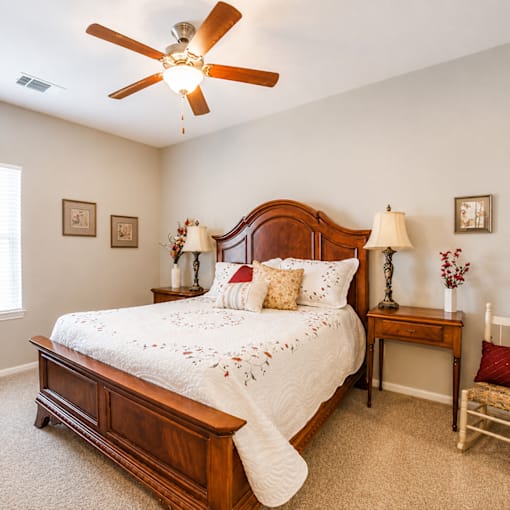 A bedroom with a large bed and a ceiling fan.