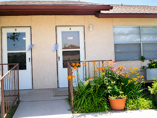 A house with a white door and a brown railing.