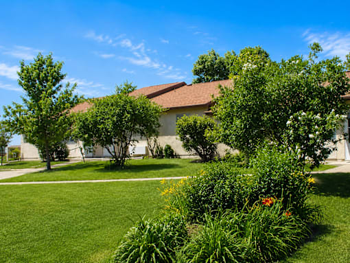 A house with a lawn and trees in front of it.