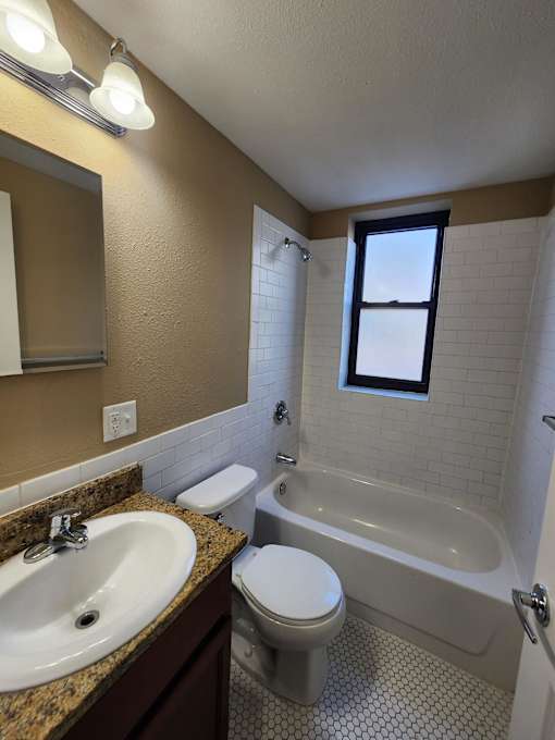 A bathroom with a sink, toilet, and bathtub.