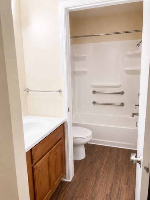 A white toilet is in a small bathroom with a walk-in shower.