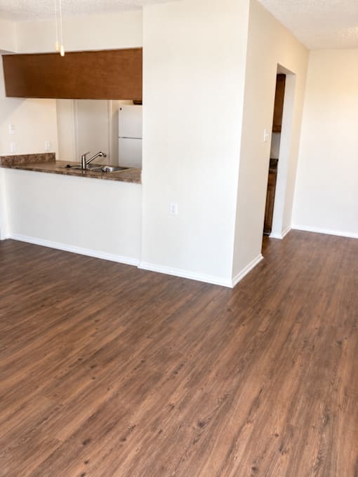 A kitchen with a white counter and brown cabinets.