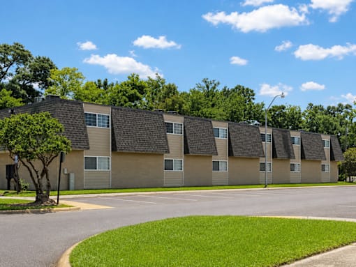 Apartment complex with a tree in front of it.