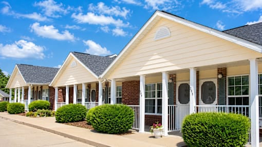 A row of houses with white columns and porches.