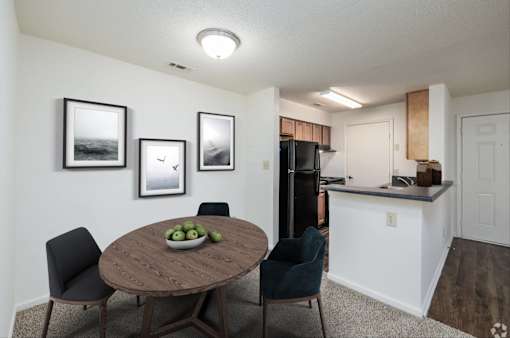 A dining room with a table and chairs.