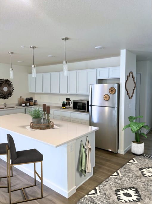 a kitchen with a white counter top and a stainless steel refrigerator