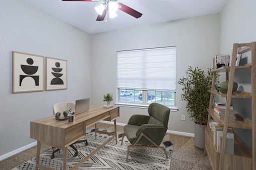 A room with a desk, chair, and a fan.