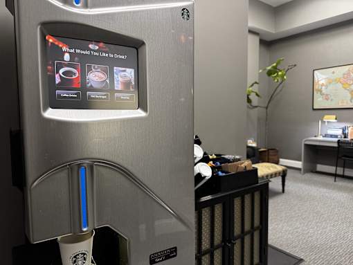 A vending machine with a screen asking "What Would You Like to Drink".