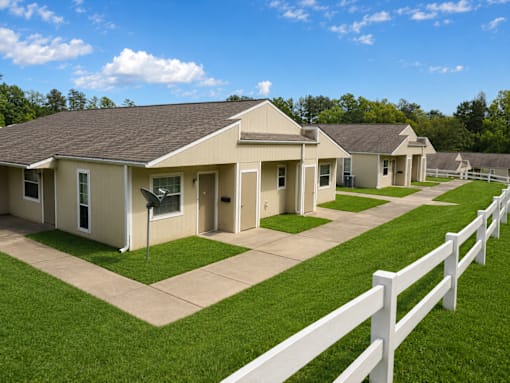 A white picket fence separates a row of houses.