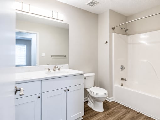 A white bathroom with a toilet, sink, and bathtub.