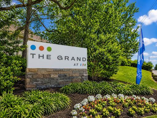 A sign that says "The Grand" in front of a building.