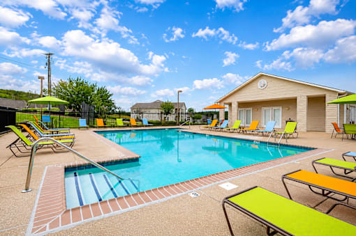 A pool with a slide and sun loungers.