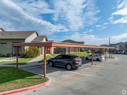 A parking lot with cars and a building in the background.