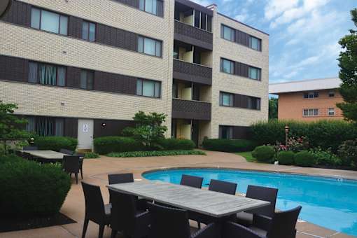Poolside table and chairs are set up outside a building.