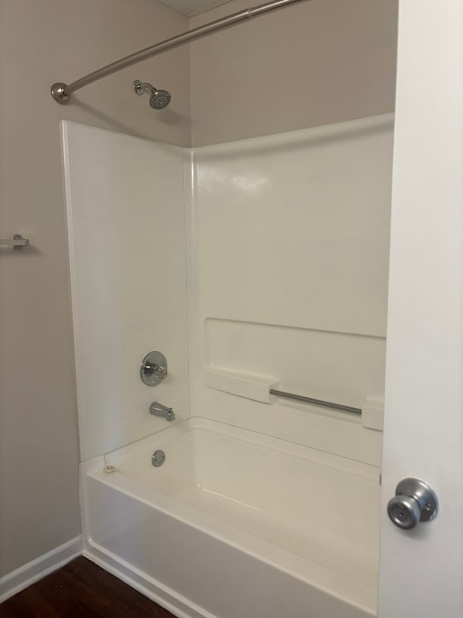 A white bathroom with a tub and shower.