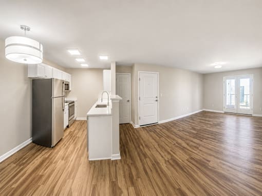 A kitchen with wooden floors and white appliances.