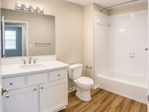 A white bathroom with a toilet, sink, and bathtub.