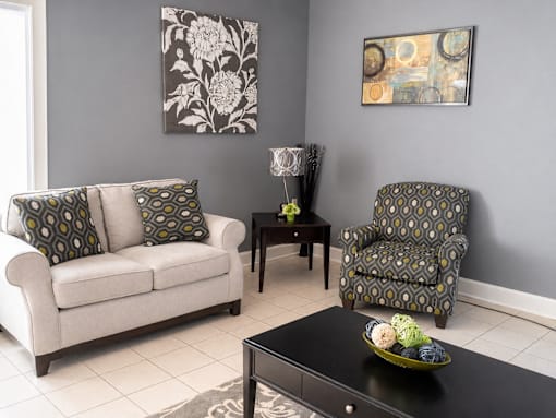 A living room with a couch, chair, and table.