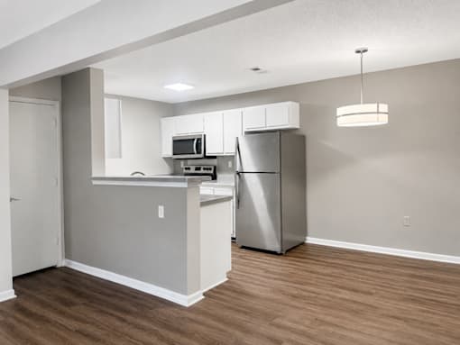 A kitchen with a refrigerator, microwave, and oven.