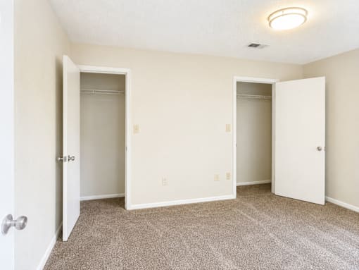 A room with two open doors and a carpeted floor.