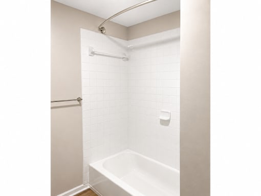 A white tiled shower stall with a white tub.