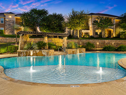 A large swimming pool with a fountain in the middle of it.