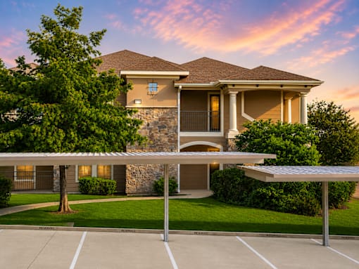 A house with a stone wall and a covered parking area.