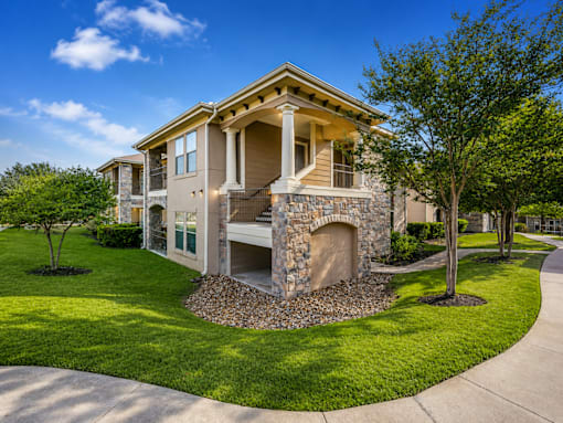 A house with a stone fireplace in front of it.