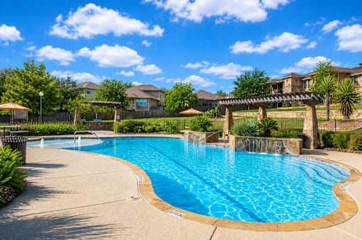 A large outdoor swimming pool with a bridge over it.
