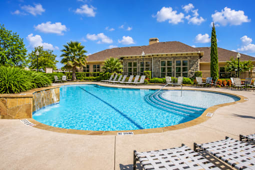 A large swimming pool with a sign that says "NO DIVING" in front of a house.